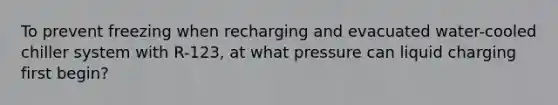 To prevent freezing when recharging and evacuated water-cooled chiller system with R-123, at what pressure can liquid charging first begin?