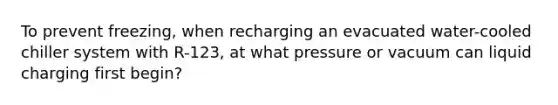 To prevent freezing, when recharging an evacuated water-cooled chiller system with R-123, at what pressure or vacuum can liquid charging first begin?