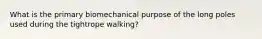 What is the primary biomechanical purpose of the long poles used during the tightrope walking?