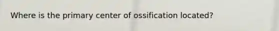 Where is the primary center of ossification located?