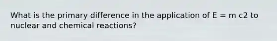 What is the primary difference in the application of E = m c2 to nuclear and chemical reactions?