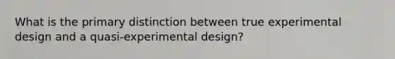 What is the primary distinction between true experimental design and a quasi-experimental design?