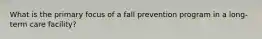 What is the primary focus of a fall prevention program in a long-term care facility?