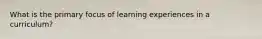 What is the primary focus of learning experiences in a curriculum?