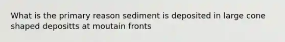 What is the primary reason sediment is deposited in large cone shaped depositts at moutain fronts