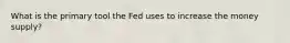 What is the primary tool the Fed uses to increase the money supply?