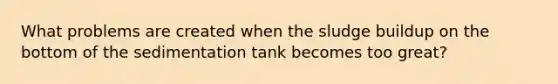 What problems are created when the sludge buildup on the bottom of the sedimentation tank becomes too great?