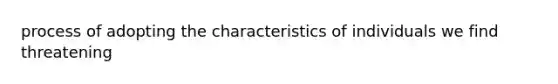 process of adopting the characteristics of individuals we find threatening