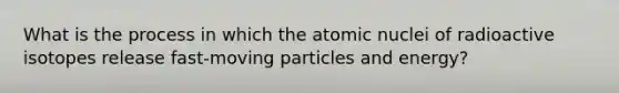 What is the process in which the atomic nuclei of radioactive isotopes release fast-moving particles and energy?