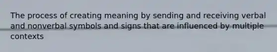 The process of creating meaning by sending and receiving verbal and nonverbal symbols and signs that are influenced by multiple contexts