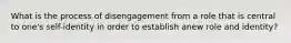 What is the process of disengagement from a role that is central to one's self-identity in order to establish anew role and identity?