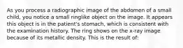 As you process a radiographic image of the abdomen of a small child, you notice a small ringlike object on the image. It appears this object is in the patient's stomach, which is consistent with the examination history. The ring shows on the x-ray image because of its metallic density. This is the result of: