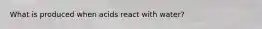 What is produced when acids react with water?