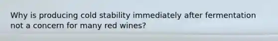 Why is producing cold stability immediately after fermentation not a concern for many red wines?