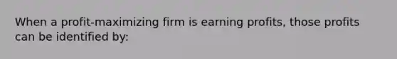 When a profit-maximizing firm is earning profits, those profits can be identified by: