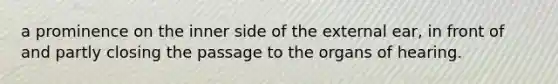 a prominence on the inner side of the external ear, in front of and partly closing the passage to the organs of hearing.