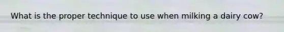 What is the proper technique to use when milking a dairy cow?