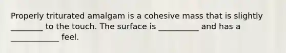 Properly triturated amalgam is a cohesive mass that is slightly ________ to the touch. The surface is __________ and has a ____________ feel.