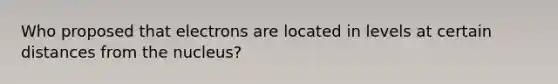 Who proposed that electrons are located in levels at certain distances from the nucleus?