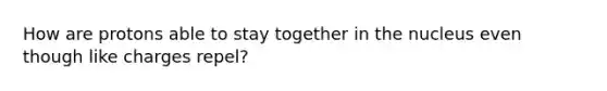 How are protons able to stay together in the nucleus even though like charges repel?