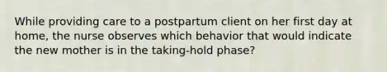 While providing care to a postpartum client on her first day at home, the nurse observes which behavior that would indicate the new mother is in the taking-hold phase?