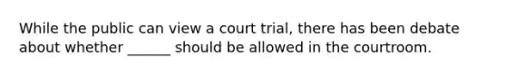 While the public can view a court trial, there has been debate about whether ______ should be allowed in the courtroom.