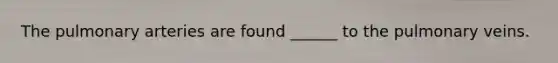 The pulmonary arteries are found ______ to the pulmonary veins.