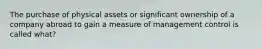 The purchase of physical assets or significant ownership of a company abroad to gain a measure of management control is called what?