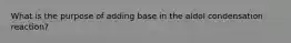 What is the purpose of adding base in the aldol condensation reaction?