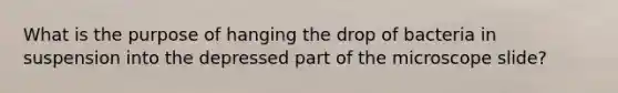 What is the purpose of hanging the drop of bacteria in suspension into the depressed part of the microscope slide?