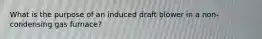 What is the purpose of an induced draft blower in a non-condensing gas furnace?