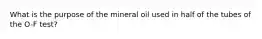 What is the purpose of the mineral oil used in half of the tubes of the O-F test?