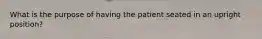 What is the purpose of having the patient seated in an upright position?