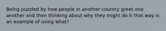 Being puzzled by how people in another country greet one another and then thinking about why they might do it that way is an example of using what?