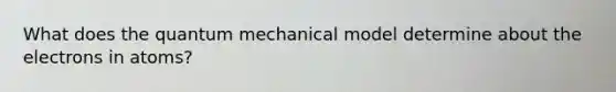 What does the quantum mechanical model determine about the electrons in atoms?