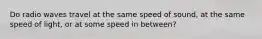 Do radio waves travel at the same speed of sound, at the same speed of light, or at some speed in between?