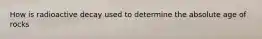 How is radioactive decay used to determine the absolute age of rocks