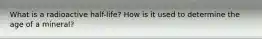 What is a radioactive half-life? How is it used to determine the age of a mineral?
