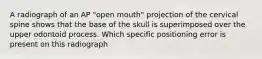 A radiograph of an AP "open mouth" projection of the cervical spine shows that the base of the skull is superimposed over the upper odontoid process. Which specific positioning error is present on this radiograph