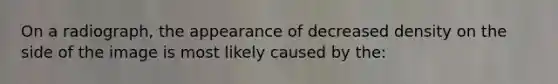 On a radiograph, the appearance of decreased density on the side of the image is most likely caused by the: