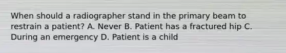 When should a radiographer stand in the primary beam to restrain a patient? A. Never B. Patient has a fractured hip C. During an emergency D. Patient is a child