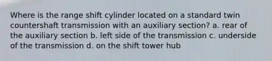 Where is the range shift cylinder located on a standard twin countershaft transmission with an auxiliary section? a. rear of the auxiliary section b. left side of the transmission c. underside of the transmission d. on the shift tower hub