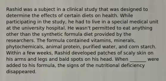 Rashid was a subject in a clinical study that was designed to determine the effects of certain diets on health. While participating in the study, he had to live in a special medical unit at the university hospital. He wasn't permitted to eat anything other than the synthetic formula diet provided by the researchers. The formula contained vitamins, minerals, phytochemicals, animal protein, purified water, and corn starch. Within a few weeks, Rashid developed patches of scaly skin on his arms and legs and bald spots on his head. When _______ were added to his formula, the signs of the nutritional deficiency disappeared.