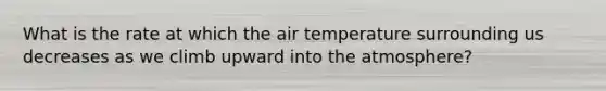 What is the rate at which the air temperature surrounding us decreases as we climb upward into the atmosphere?