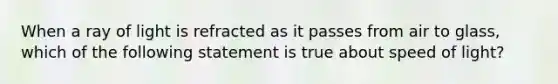 When a ray of light is refracted as it passes from air to glass, which of the following statement is true about speed of light?