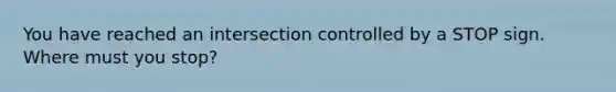 You have reached an intersection controlled by a STOP sign. Where must you stop?