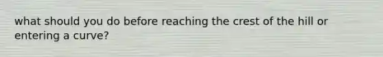 what should you do before reaching the crest of the hill or entering a curve?