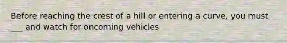 Before reaching the crest of a hill or entering a curve, you must ___ and watch for oncoming vehicles