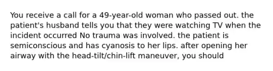 You receive a call for a 49-year-old woman who passed out. the patient's husband tells you that they were watching TV when the incident occurred No trauma was involved. the patient is semiconscious and has cyanosis to her lips. after opening her airway with the head-tilt/chin-lift maneuver, you should