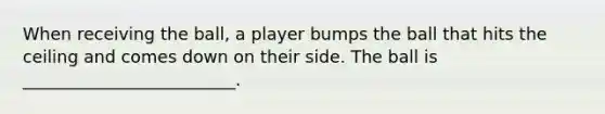 When receiving the ball, a player bumps the ball that hits the ceiling and comes down on their side. The ball is _________________________.